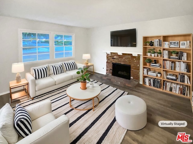 living room with dark hardwood / wood-style flooring and a brick fireplace