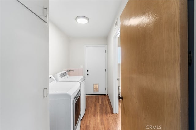 washroom featuring light hardwood / wood-style floors and independent washer and dryer