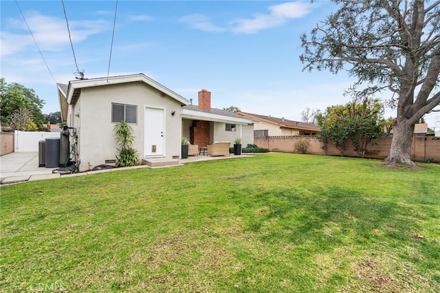 rear view of property featuring a yard and central AC unit