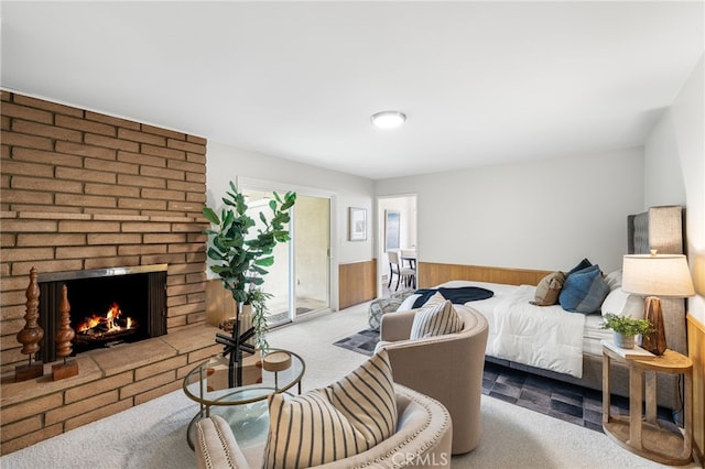 bedroom with a brick fireplace, access to outside, and light colored carpet