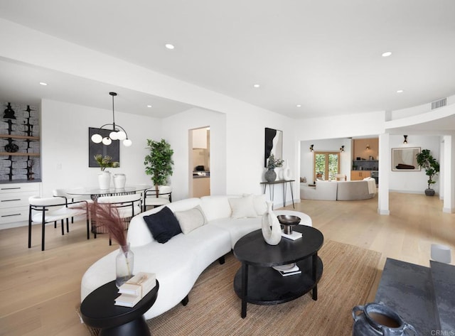 living room featuring a notable chandelier and light hardwood / wood-style floors