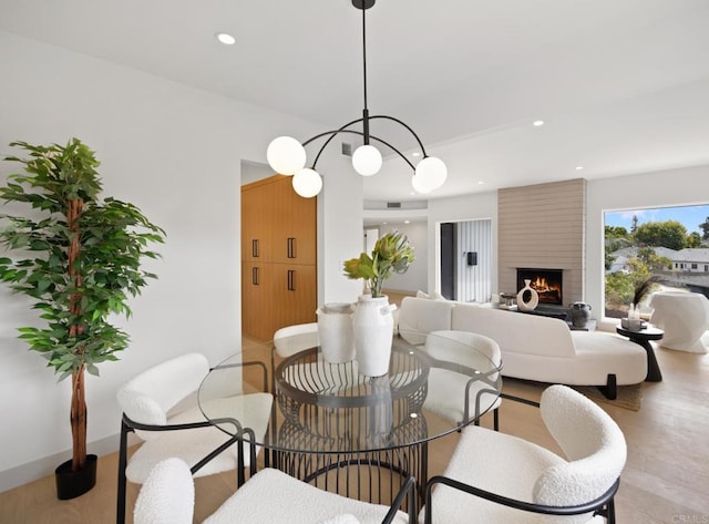 dining area with a large fireplace and light wood-type flooring