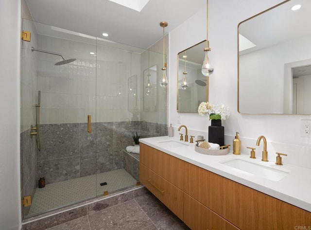 bathroom with a skylight, vanity, tile patterned flooring, and walk in shower