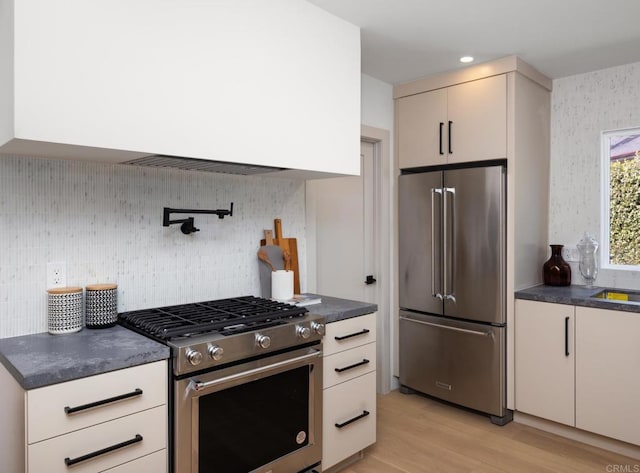 kitchen with tasteful backsplash, appliances with stainless steel finishes, and light wood-type flooring