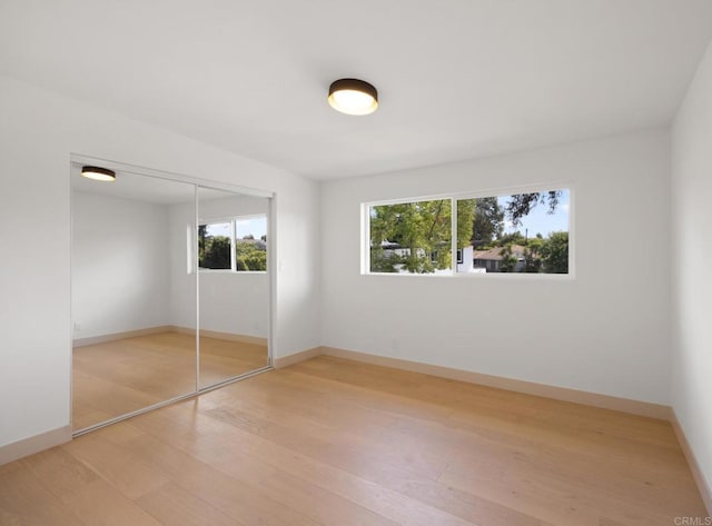 unfurnished bedroom featuring wood-type flooring and a closet