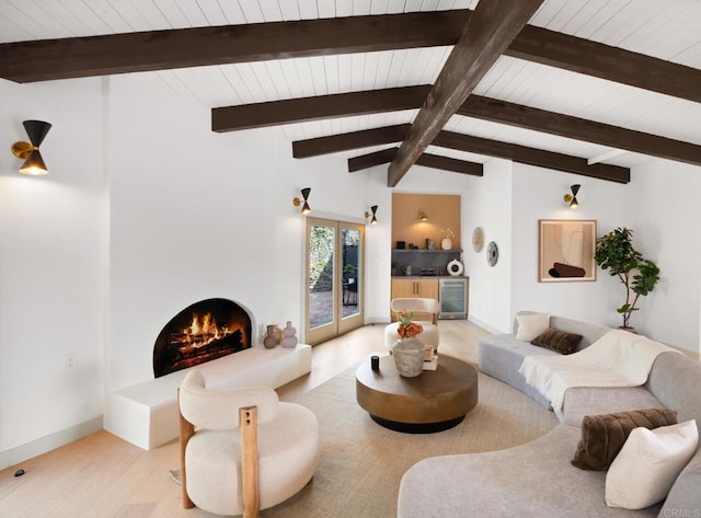 living room featuring vaulted ceiling with beams, light hardwood / wood-style floors, and beverage cooler