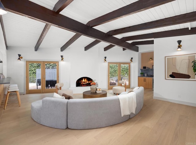 living room with lofted ceiling with beams, light wood-type flooring, and french doors