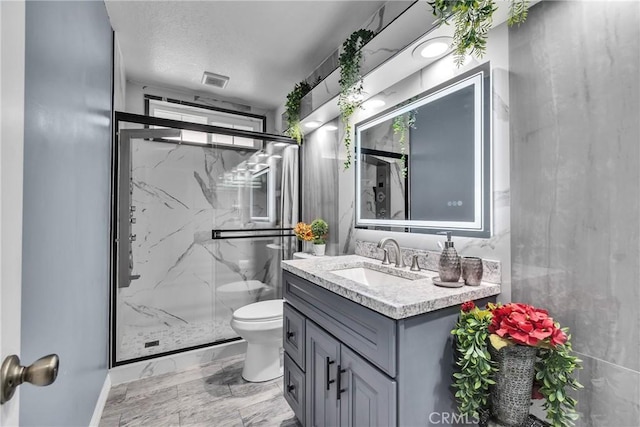 bathroom featuring vanity, an enclosed shower, and toilet