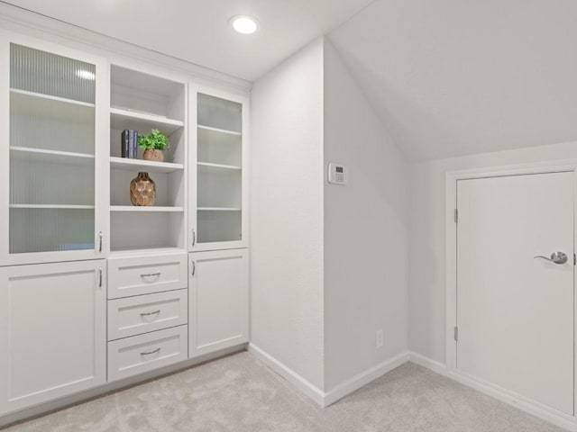 interior space featuring light colored carpet and vaulted ceiling