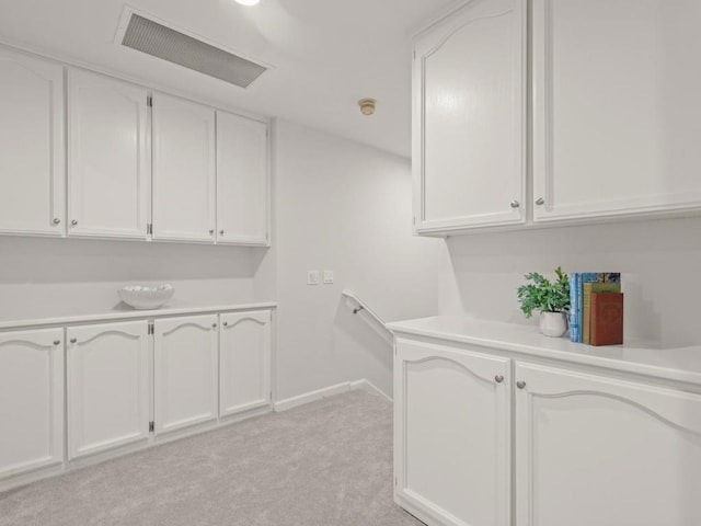 bar featuring white cabinetry and light colored carpet