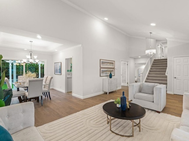 living room featuring an inviting chandelier, crown molding, and light hardwood / wood-style floors