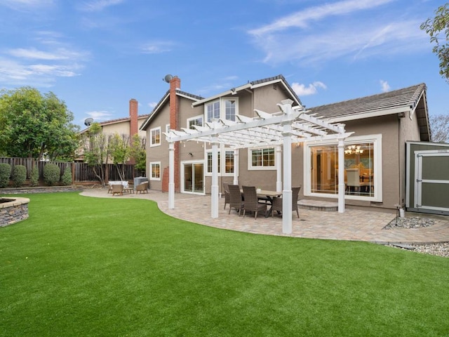 back of property with a lawn, a patio area, and a pergola