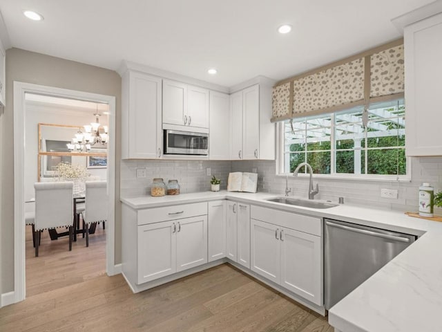 kitchen featuring sink, light wood-type flooring, white cabinets, and appliances with stainless steel finishes