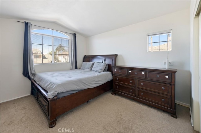 bedroom with lofted ceiling, light colored carpet, and baseboards