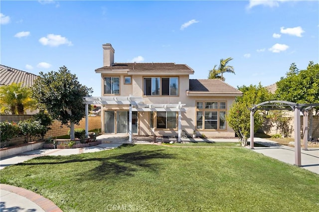 rear view of house with a yard, stucco siding, fence, and a pergola