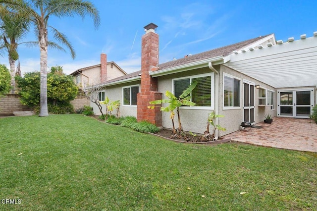 rear view of house featuring a lawn and a patio area