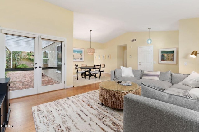 living room with wood-type flooring and vaulted ceiling