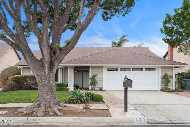 single story home with a garage and a front lawn