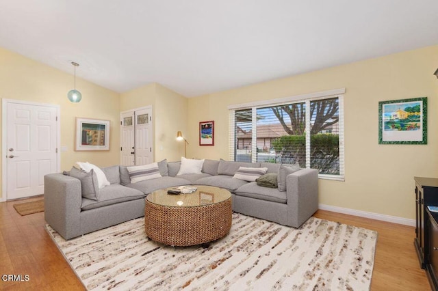 living room featuring light hardwood / wood-style flooring and vaulted ceiling