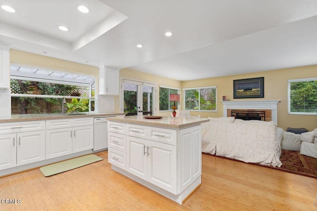 kitchen with white cabinetry, white dishwasher, a wealth of natural light, and a center island