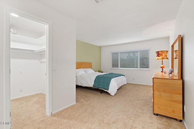 bedroom featuring a spacious closet and light colored carpet