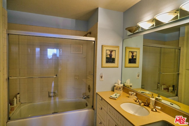 bathroom with vanity and shower / bath combination with glass door