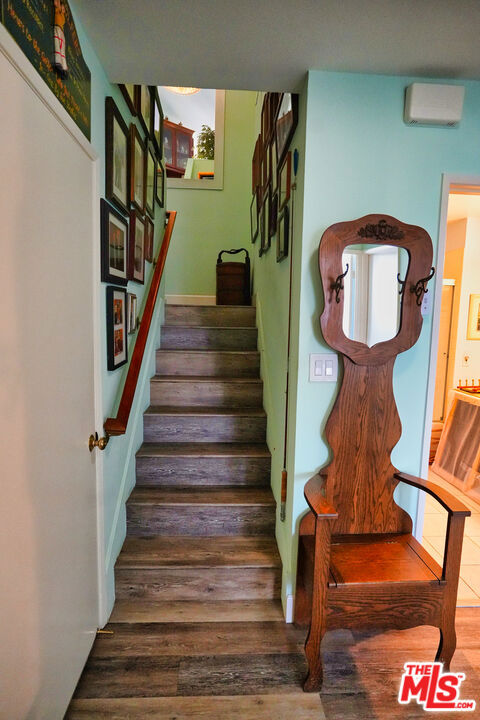 staircase with hardwood / wood-style flooring and a wall mounted AC