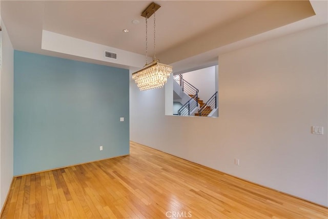 unfurnished dining area featuring hardwood / wood-style flooring and a notable chandelier