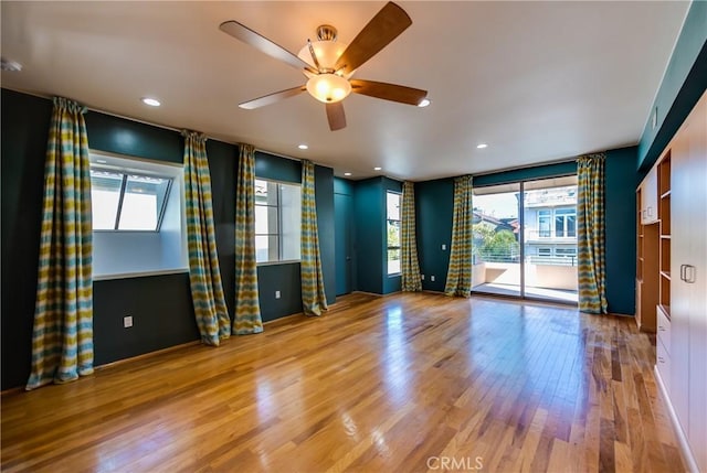 empty room with ceiling fan and light wood-type flooring