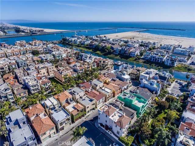 birds eye view of property with a water view and a beach view