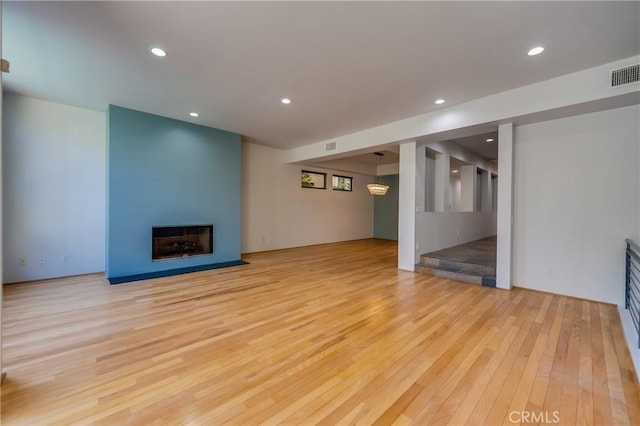 unfurnished living room with light hardwood / wood-style flooring and a fireplace