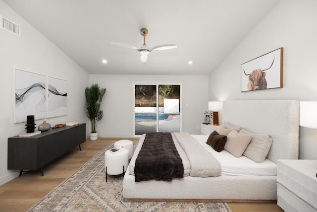 bedroom featuring ceiling fan, light hardwood / wood-style floors, vaulted ceiling, and access to outside