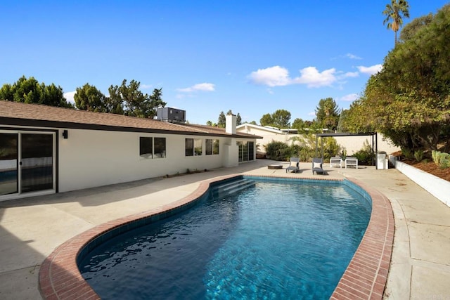 view of swimming pool with central AC unit and a patio