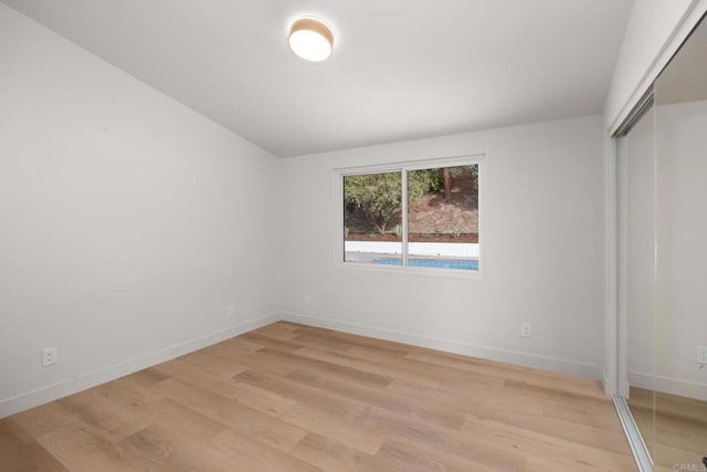 unfurnished bedroom with light hardwood / wood-style flooring and a closet