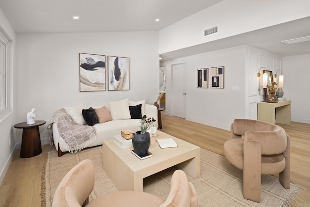 living room featuring vaulted ceiling and light wood-type flooring