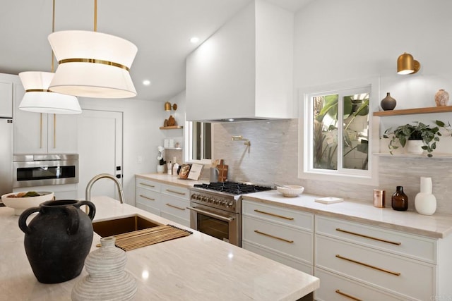 kitchen featuring white cabinetry, oven, high end stainless steel range oven, hanging light fixtures, and light stone counters