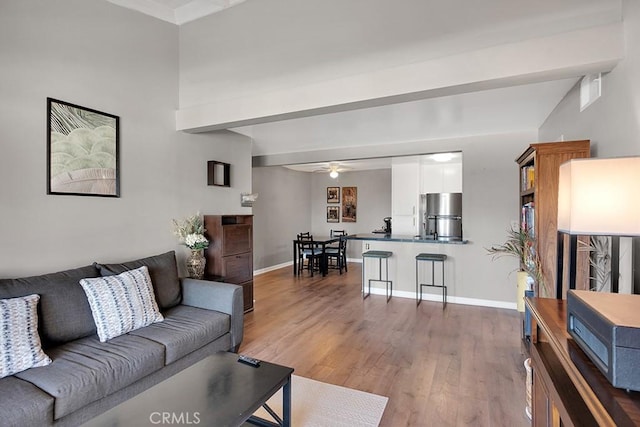 living room featuring beamed ceiling, ceiling fan, and dark hardwood / wood-style flooring