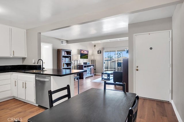 kitchen with sink, light hardwood / wood-style flooring, white cabinets, and kitchen peninsula