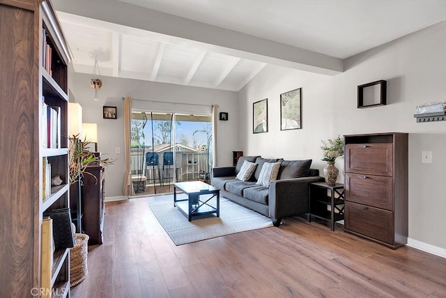 living room featuring vaulted ceiling with beams and hardwood / wood-style flooring