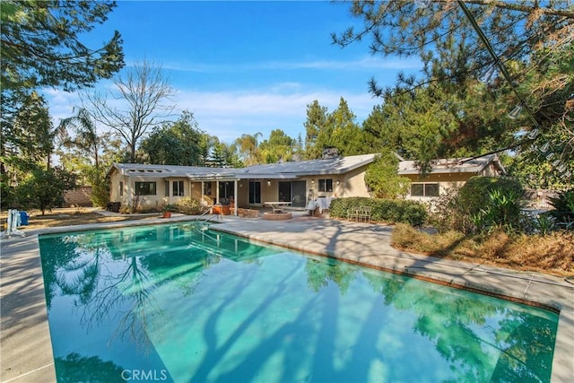 view of pool featuring an outdoor fire pit and a patio area