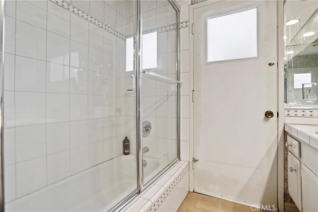 bathroom with enclosed tub / shower combo and vanity