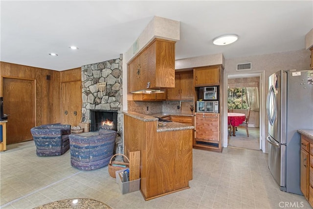 kitchen with tasteful backsplash, a fireplace, and stainless steel appliances