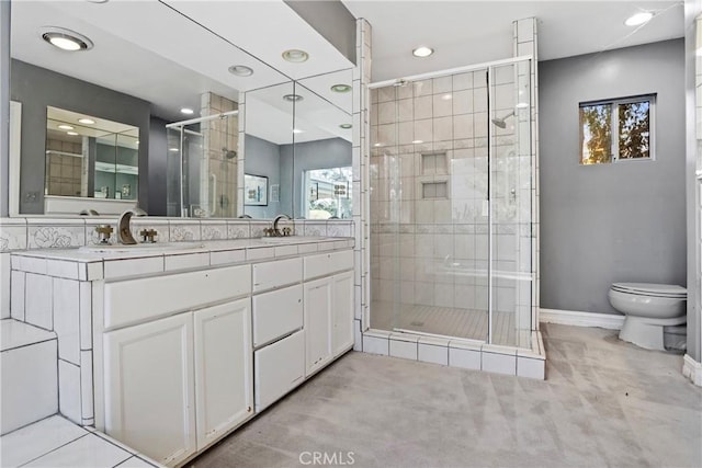 bathroom with vanity, a shower with shower door, and toilet