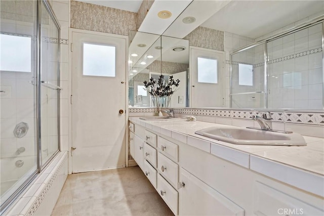 bathroom featuring vanity and bath / shower combo with glass door