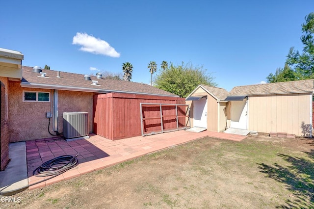 view of yard featuring an outbuilding, central AC, and a patio