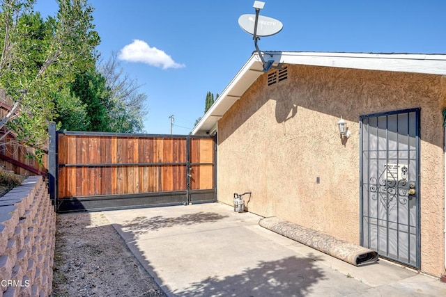 view of gate with a patio area and fence