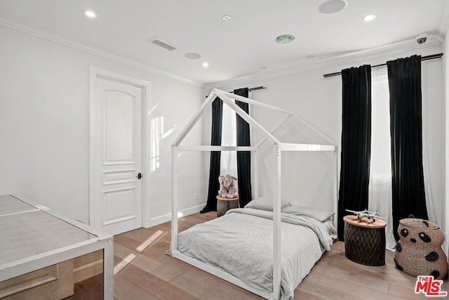 bedroom with hardwood / wood-style flooring and ornamental molding