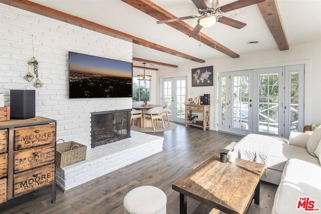 living room with beamed ceiling, a brick fireplace, dark wood-type flooring, and french doors