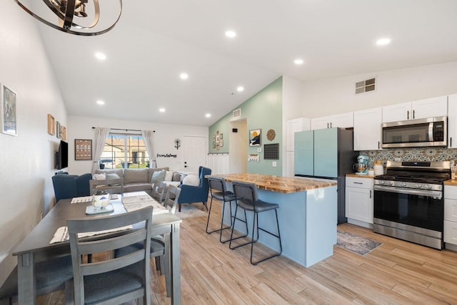 kitchen featuring stainless steel appliances, a center island, white cabinets, and a breakfast bar