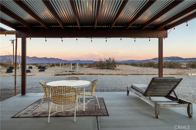 patio terrace at dusk featuring a mountain view